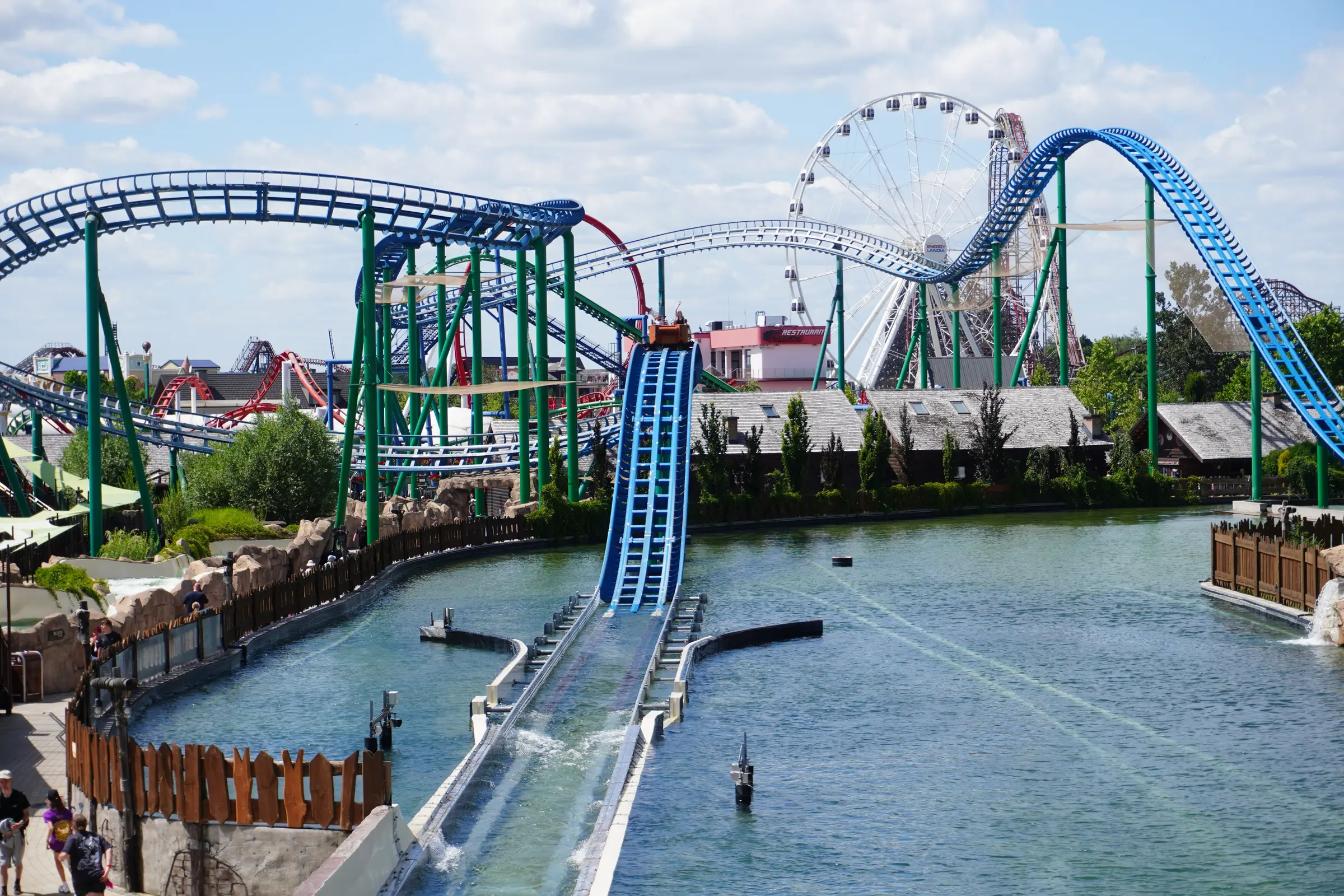 Parc d'attractions avec montagnes russes au-dessus d'un plan d'eau
